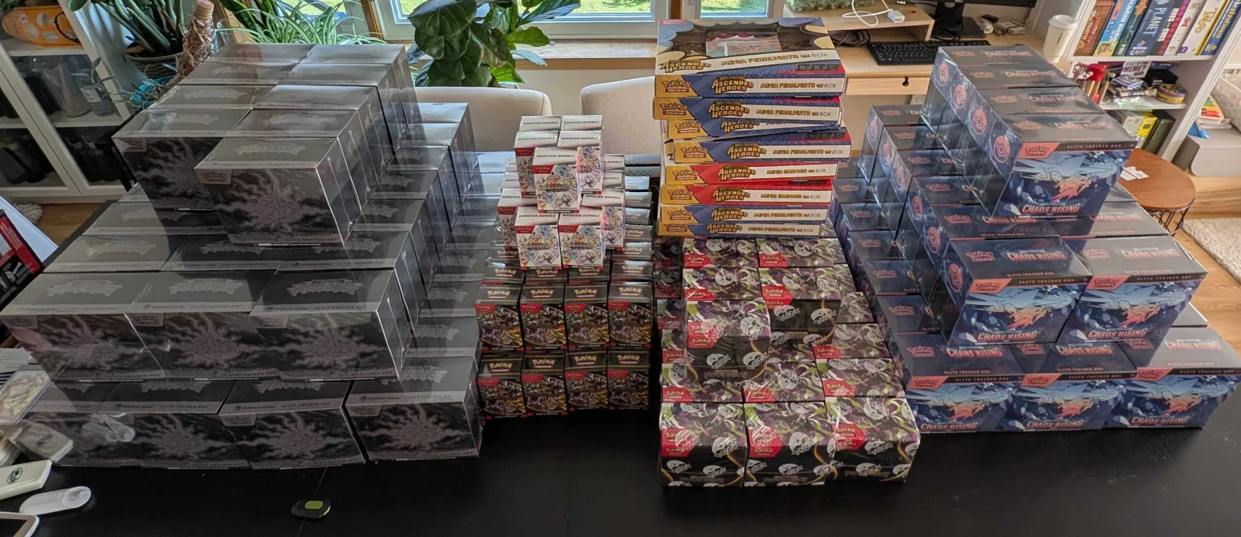 Large member-supplied collection of sealed Pokémon and other trading card game products arranged on a table